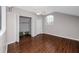 A bright bedroom features hardwood floors, fan, closet, and bright window at 335 Palmdale Dr, Oldsmar, FL 34677