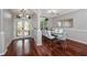 Bright dining room with white and blue chairs, dark hardwood flooring, and a doorway to the entry at 335 Palmdale Dr, Oldsmar, FL 34677