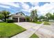 Exterior view of single Gathering home with lush landscaping, a large two-car driveway, and two-car garage at 335 Palmdale Dr, Oldsmar, FL 34677