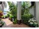 Brick-paved walkway flanked by lush tropical landscaping with garden statues leading to a home's entrance at 335 Palmdale Dr, Oldsmar, FL 34677