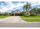 Charming home with a three-car garage, spacious driveway, manicured lawn and tropical landscaping at 335 Palmdale Dr, Oldsmar, FL 34677