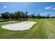 A sand trap surrounded by lush green grass on a beautiful golf course is a golfer's paradise at 335 Palmdale Dr, Oldsmar, FL 34677