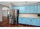 Light blue kitchen cabinets compliment stainless steel refrigerator and marble backsplash and countertops, perfect for cooking at 335 Palmdale Dr, Oldsmar, FL 34677
