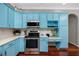 Updated kitchen with sleek stainless steel appliances, light blue cabinets, and elegant marble backsplash and countertops at 335 Palmdale Dr, Oldsmar, FL 34677