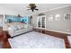 Open living room showcases hardwood floors, light blue kitchen, stylish rug, and natural light at 335 Palmdale Dr, Oldsmar, FL 34677