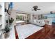Open floor plan living room with hardwood floors, television, and screened-in pool view at 335 Palmdale Dr, Oldsmar, FL 34677