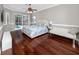 Bright main bedroom with hardwood floors, ceiling fan, walkout access, and a serene view of the pool at 335 Palmdale Dr, Oldsmar, FL 34677