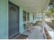 Inviting front porch with seating, a storm door, and light blue exterior at 3440 Pittman Rd, Dover, FL 33527
