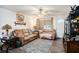 Bright living room with wood-look floors, a ceiling fan, and comfortable seating at 3440 Pittman Rd, Dover, FL 33527