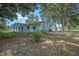 Light blue home showcasing a spacious backyard with mature trees at 3440 Pittman Rd, Dover, FL 33527