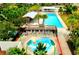Aerial view of a community pool, splash pad, and lounging area surrounded by palm trees and greenery, a luxury amenity at 3984 Maurice Ave, Odessa, FL 33556