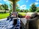 Inviting front porch with wicker furniture and a patterned rug under the column, showing a serene outdoor living space at 3984 Maurice Ave, Odessa, FL 33556