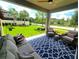 Relaxing covered patio with comfortable seating, ceiling fan, and beautiful backyard views at 3984 Maurice Ave, Odessa, FL 33556