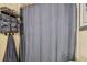 Bathroom features a shower with waffle weave curtain, gray towels and shelving for storage at 4114 Pinelake Ln # 202, Tampa, FL 33618