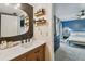 Elegant bathroom with wood vanity, quartz countertop, and shelves, open to the primary bedroom at 4114 Pinelake Ln # 202, Tampa, FL 33618