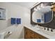 Bright bathroom featuring a dual sink vanity, a large mirror with lighting, and tasteful decor at 4114 Pinelake Ln # 202, Tampa, FL 33618