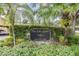 Pine Lake Garden Villas sign surrounded by lush landscaping, creating a welcoming entrance to the Carrollwood Village community at 4114 Pinelake Ln # 202, Tampa, FL 33618