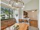 Charming dining room featuring a modern chandelier, brick accent wall, and an open view to the kitchen at 4114 Pinelake Ln # 202, Tampa, FL 33618