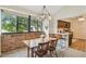 Bright dining area with a large window, brick wall, and modern lighting fixture, adjacent to the kitchen at 4114 Pinelake Ln # 202, Tampa, FL 33618