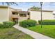 Charming condo featuring well-maintained landscaping and a inviting walkway leading to the front entrance at 4114 Pinelake Ln # 202, Tampa, FL 33618