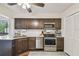 Contemporary kitchen with stainless steel appliances, dark cabinetry, and bright countertops at 4114 Pinelake Ln # 202, Tampa, FL 33618