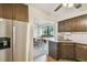 Renovated kitchen featuring stainless steel appliances, dark cabinets, and a view to the dining room at 4114 Pinelake Ln # 202, Tampa, FL 33618