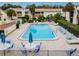 Relaxing pool area with lounge chairs and umbrellas surrounded by condo villas in a beautiful community at 4114 Pinelake Ln # 202, Tampa, FL 33618