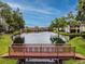 Waterfront living featuring a tranquil pond with fountain, bridge, and community condos at 4114 Pinelake Ln # 202, Tampa, FL 33618