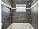 Close up of the bathroom, with dark tile, a window, and shower at 483 32Nd N Ave, St Petersburg, FL 33704