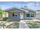 Charming home featuring updated gray paint, new windows, and inviting curb appeal with sidewalk leading to the front door at 483 32Nd N Ave, St Petersburg, FL 33704