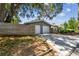 Two-car garage with updated white doors, with mature trees providing ample shade at 483 32Nd N Ave, St Petersburg, FL 33704