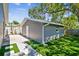 Detached gray garage with white door and lush green lawn at 483 32Nd N Ave, St Petersburg, FL 33704