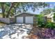 Two-car garage with updated white doors, adjacent to a wooden privacy fence and greenery at 483 32Nd N Ave, St Petersburg, FL 33704