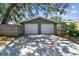 Two-car garage with updated white doors, surrounded by a wooden fence and lush greenery at 483 32Nd N Ave, St Petersburg, FL 33704