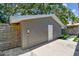 Exterior of detached garage with gray siding, a white door, and green grass at 483 32Nd N Ave, St Petersburg, FL 33704