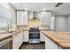 Bright kitchen features stainless steel appliances, sleek white cabinets, and butcher block countertops at 483 32Nd N Ave, St Petersburg, FL 33704