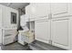 Utility room features a stacked washer/dryer and ample white storage cabinets at 483 32Nd N Ave, St Petersburg, FL 33704