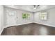 Bright living room featuring dark wood flooring, a ceiling fan, and two windows with natural light at 483 32Nd N Ave, St Petersburg, FL 33704