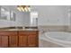 Bathroom featuring double sinks, granite countertops, soaking tub, and tile surround at 5030 Herring Ct, New Port Richey, FL 34652