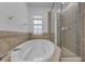 Well-lit bathroom featuring a soaking tub and a glass-enclosed shower at 5030 Herring Ct, New Port Richey, FL 34652