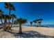 Picturesque beach with soft, white sand, swaying palm trees, and clear blue waters, perfect for relaxation and recreation at 5030 Herring Ct, New Port Richey, FL 34652