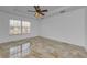 Bright bedroom featuring tile flooring, ceiling fan, and a window providing natural light at 5030 Herring Ct, New Port Richey, FL 34652