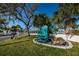 Charming Adirondack chair next to tropical trees, inviting you to relax and enjoy the island lifestyle at 5030 Herring Ct, New Port Richey, FL 34652
