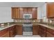 Kitchen featuring dark wood cabinets, stainless steel appliances, mosaic tile backsplash, and granite countertops at 5030 Herring Ct, New Port Richey, FL 34652