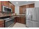 Kitchen featuring stainless steel appliances, dark wood cabinets, mosaic tile backsplash and granite countertops at 5030 Herring Ct, New Port Richey, FL 34652