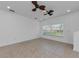 Living room with tile flooring, neutral paint, ceiling fan, and a large window at 5030 Herring Ct, New Port Richey, FL 34652