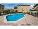 Community pool with lounge chairs, a covered patio area, and a building in the background at 5030 Herring Ct, New Port Richey, FL 34652