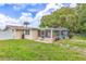 The yard features a lush lawn and a screened in pool at 5102 Peacock, Holiday, FL 34690