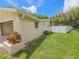 Side view of the house showing manicured lawn and a clean white fence at 5102 Peacock, Holiday, FL 34690