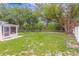 Wide shot of the backyard with a stone footpath leading to a wooded area at 5102 Peacock, Holiday, FL 34690